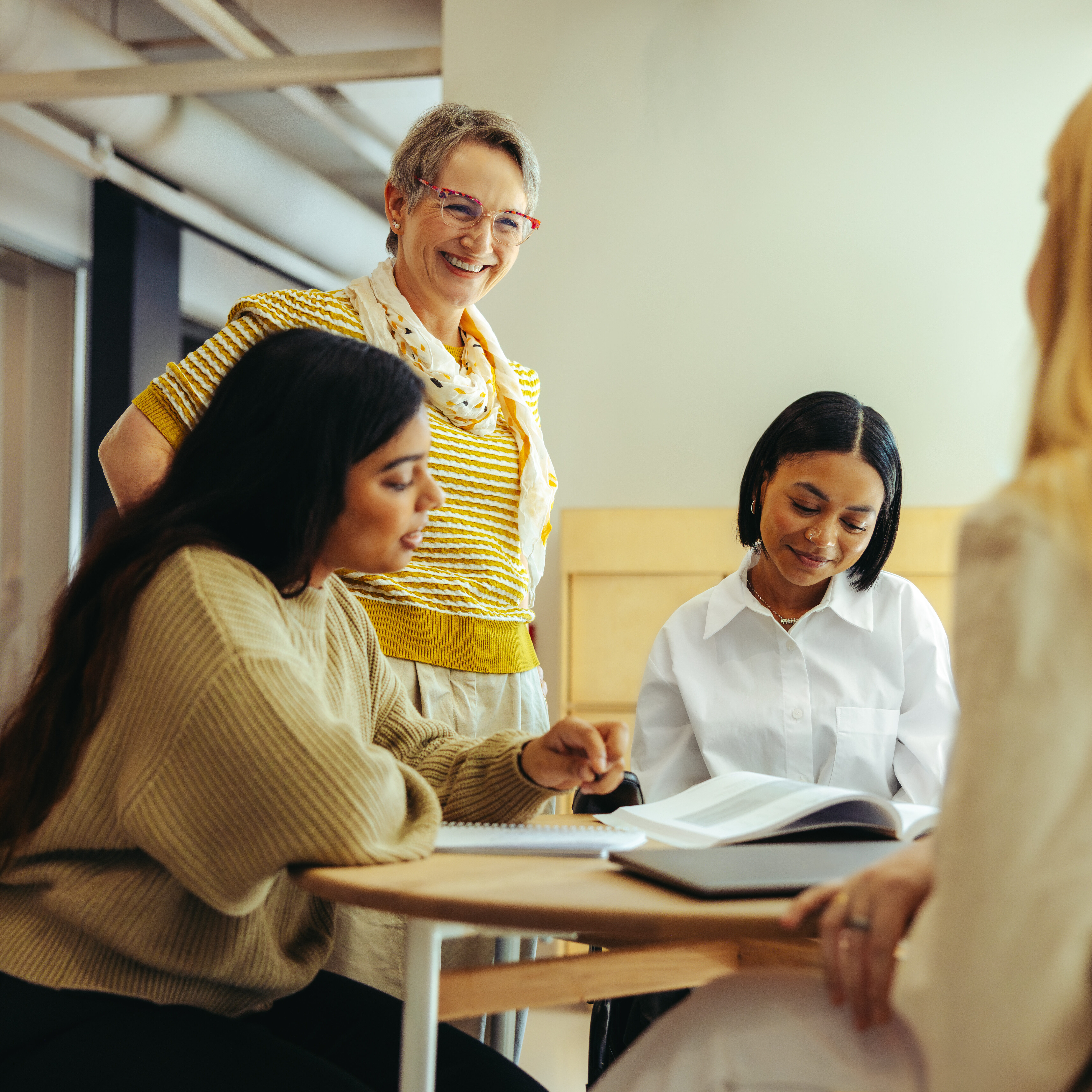 A cheerful educator interacts with students, encouraging engagement and learning in a warm and collaborative classroom atmosphere.